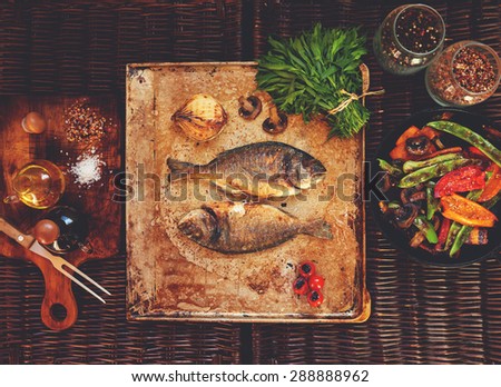 Chef prepared fish restaurant patrons to fish dorado filed grilled vegetables and all decorated with rosemary