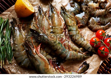 On the window of fish restaurant, is assorted shrimp, prawns, small shrimp in the shell composition decorated with cherry tomatoes and lemon