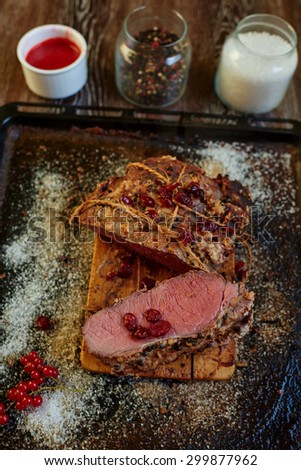 Cook the meat laid out on a baking sheet that apply to the table roasted lamb, all served with bright red berries