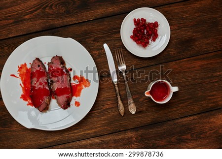 On a dark textural oak table, serving dinner on a white plate on two pieces of beef fried in rapid fire, standing next to the sauce