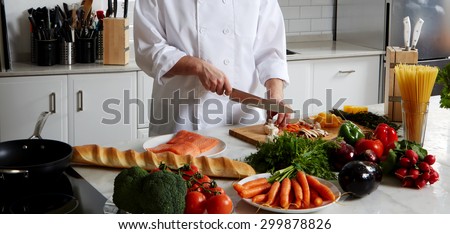 Cook is near the table, cut vegetables to fry them in a skillet and add to the Spaghetti and salmon bake in the oven