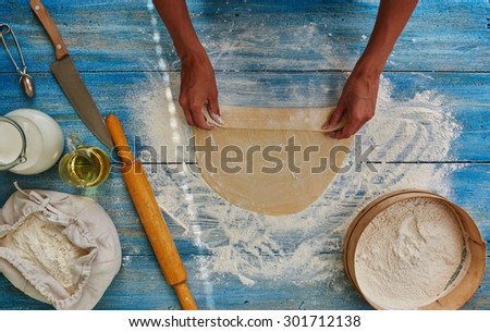 Housewife Roll out the dough and makes him roll which is baked in the oven