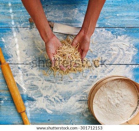 Top view of a housewife holding a sliced noodles, to add to the bitterness of the dish