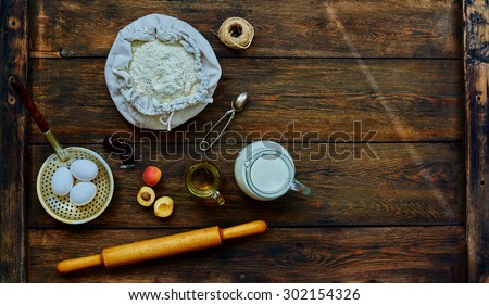 The trendy bakery chef laid on the table ingredients for bagels fresh fruit. On the table are the products for baking flour, eggs, milk and fresh fruit