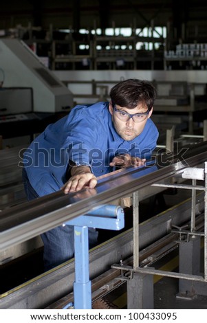 Blue-collar worker working in fabric checking aluminum