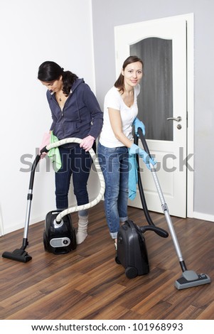 Female cleaning team vacuums a flat