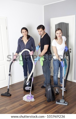 Three persons cleaning a house