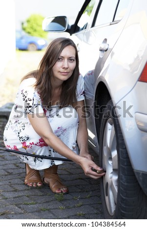 woman checking tire pressure
