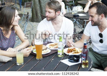 In summer garden Ã¢Â?Â? friends drinking beer and eating