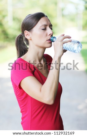 Woman drinking from water bottle after running