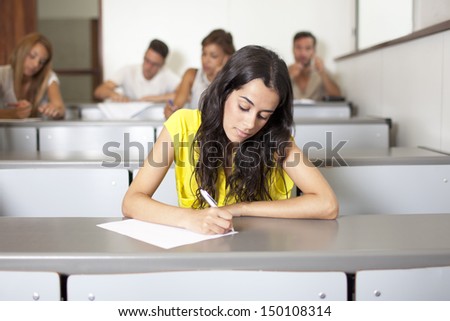 Beautiful young student writing an exam