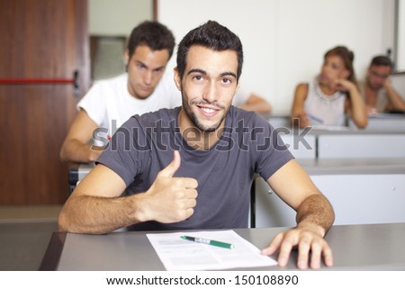 Good-looking male student writing an exam