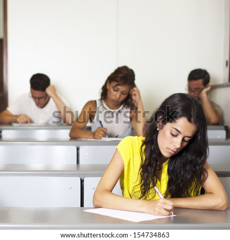 Beautiful young student writing an exam