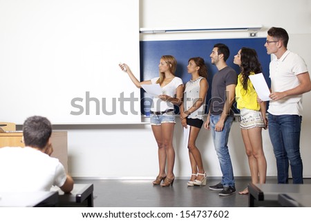 students making a presentation at blackboard