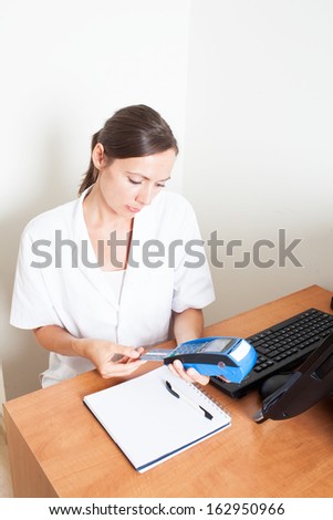 medical receptionist checking an insurance card