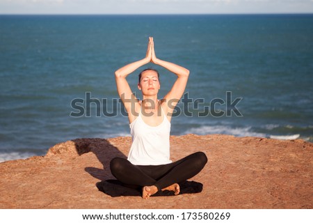 Yoga exercise sitting cross-legged on a cliff