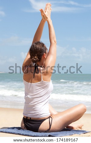 Yoga exercise sitting cross-legged rear view