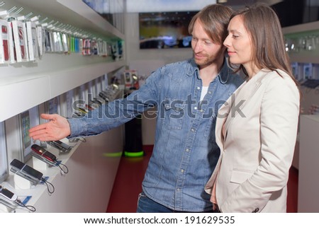 Shop assistant helping a customer choosing a smart phone