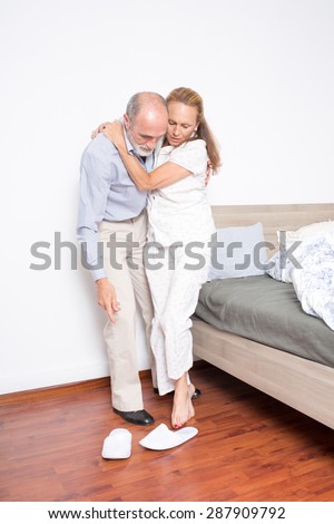 Husband helps wife to get out of bed