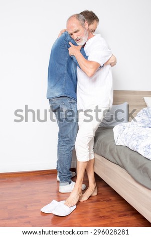 Elderly son helps father out of bed