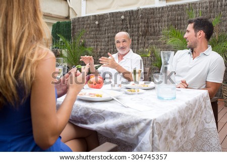 Happy family talking while having food on terrace