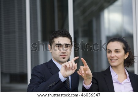 Two Businesspeople pointing on a virtual screen