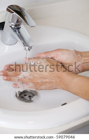 Young woman washing her hands in a sink