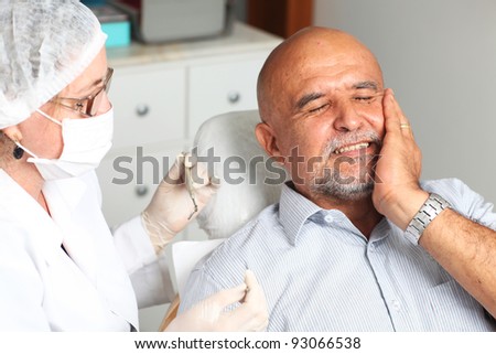 Older man with toothache at the dentist