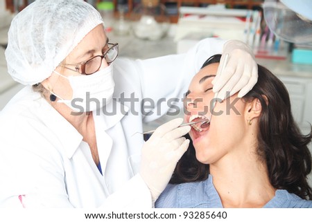 Hispanic woman at the dentist with the mouth wide open