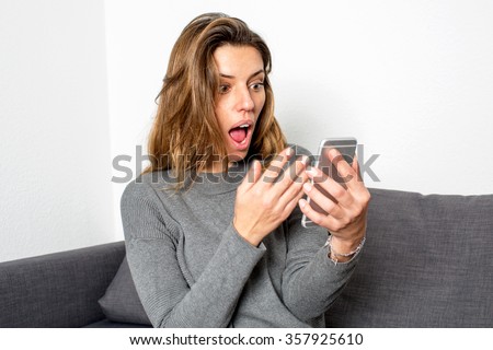 Woman surprised while looking on phone
