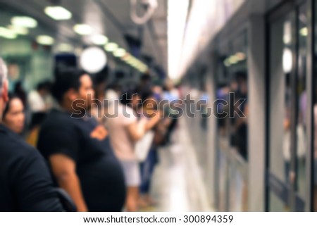 blurry image of people stand in row to get in metro train