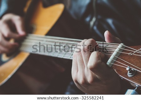 close-up, hand playing on acoustic guitar, playing chord C major position