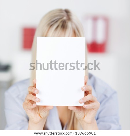 Close up shot of a woman covering her face using her tablet