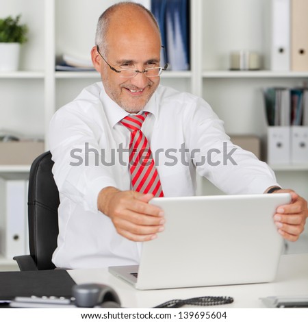 portrait of happy employee holding his laptop