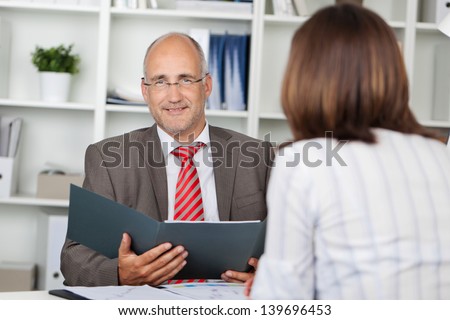 businessman holding cv, siiting at desk with female candidate