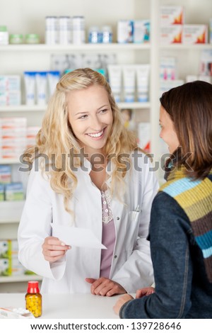Blond young pharmacist chemist woman looking for medicine in pharmacy drugstore with recipe
