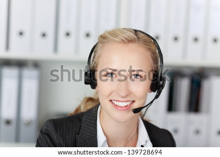Closeup of female young customer service executive using headset in office
