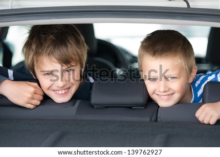 Portrait of two children smiling inside the car