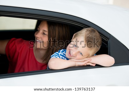 Mother and kid inside the car waiting the driver