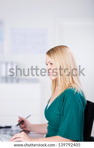Attractive female graphic designer working on tablet, smiling
