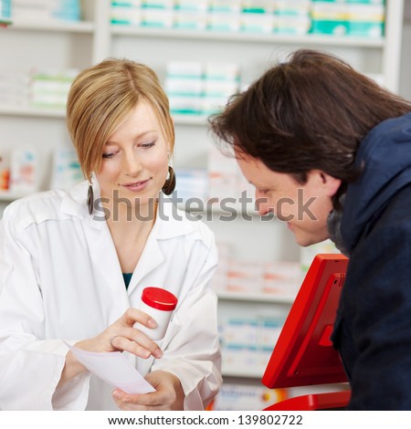 Young female pharmacist explaining prescription to customer in pharmacy Young female pharmacist explaining prescription to customer in pharmacy