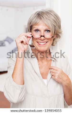 Portrait of an attractive smiling elderly lady with reading glasses