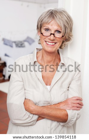 Laughing Attractive Senior Woman Wearing Glasses Standing With Folded Arms
