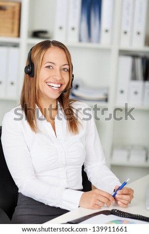 Portrait of happy female customer service executive sitting at office desk