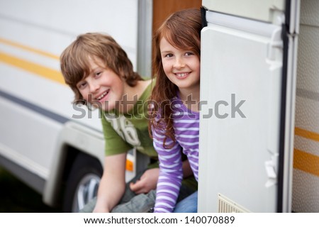 Two Kids Sitting In Doorway Of RV Two Kids Sitting In Doorway Of RV