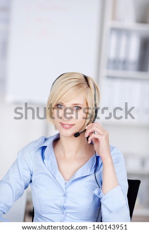 smiling costumer support executive with headset in office