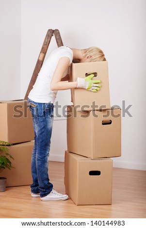 Profile shot of young woman searching something in cardboard box