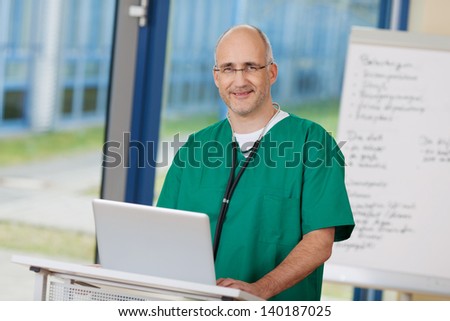 Portrait of confident mature surgeon standing at podium in clinic
