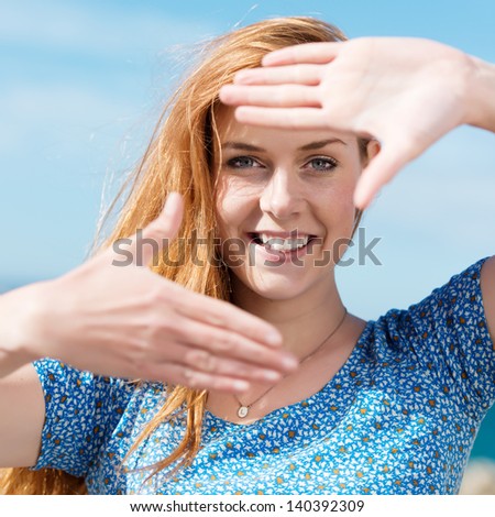Happy woman making a finger frame gesture with her hands to surround her face