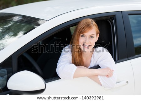 Smiling young woman sitting inside the car